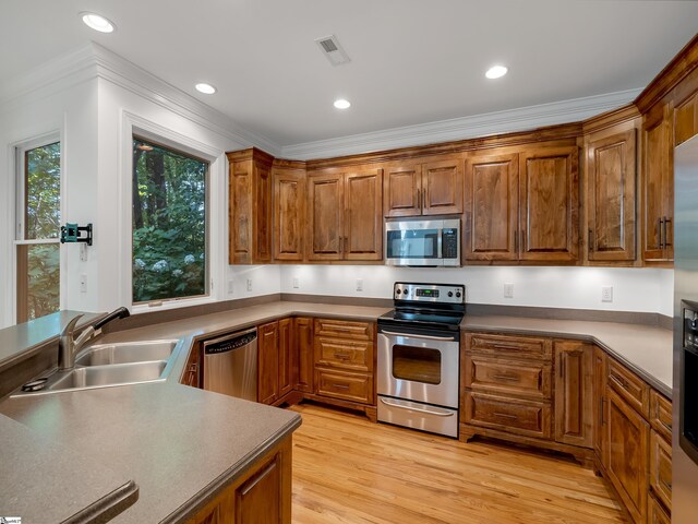 1 Touch Me Not Trl, Landrum, SC 29356 - kitchen with stainless steel appliances, brown cabinets, light wood-style flooring, ornamental molding, and recessed lighting