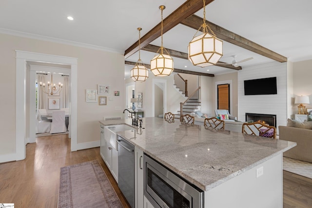 352 Pine Forest Drive Extension, Greenville, SC 29605 - kitchen with stainless steel appliances, a large fireplace, a kitchen island with sink, light stone countertops, and dark wood-style flooring