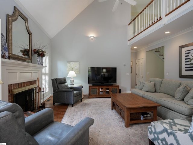 4 Glens Crossing Ct, Greer, SC 29650 - living area featuring high vaulted ceiling, ceiling fan, a brick fireplace, crown molding, and wood finished floors