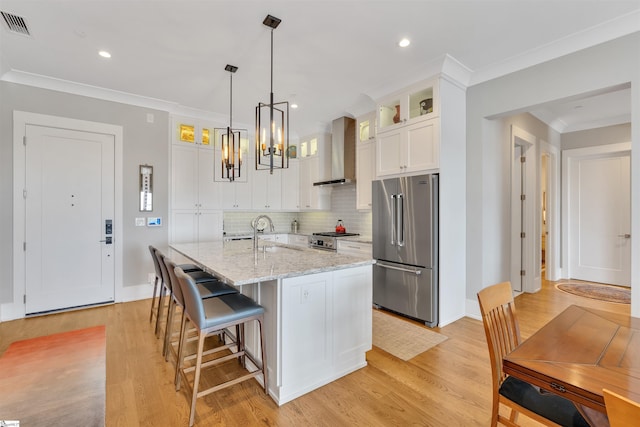 110 N Markley St Unit 505, Greenville, SC 29601 - kitchen with stainless steel appliances, wall chimney exhaust hood, a chandelier, crown molding, and white cabinetry