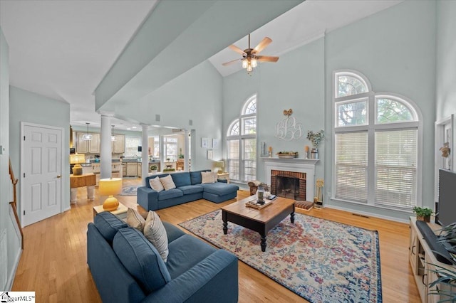 2 Willow Oak Ct, Simpsonville, SC 29681 - living room with decorative columns, a towering ceiling, plenty of natural light, ceiling fan, and a brick fireplace