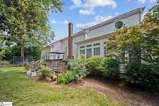 2 Willow Oak Ct, Simpsonville, SC 29681 - back of house featuring a trampoline, a wooden deck, a yard, and a chimney