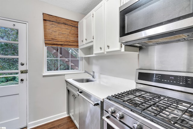 601 Cleveland St Unit 3A, Greenville, SC 29601 - kitchen featuring stainless steel appliances, white cabinetry, light countertops, dark wood-style flooring, and a textured ceiling