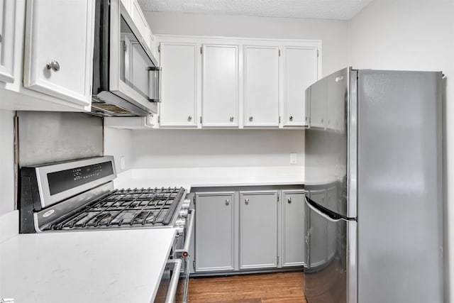 601 Cleveland St Unit 3A, Greenville, SC 29601 - kitchen with stainless steel appliances, light countertops, wood finished floors, and white cabinets
