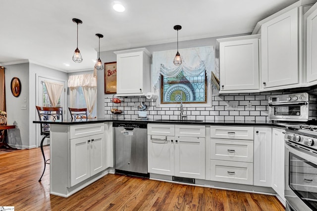 105 Devonshire Ln, Greenville, SC 29617 - kitchen with stainless steel appliances, a peninsula, dark countertops, white cabinets, and ornamental molding