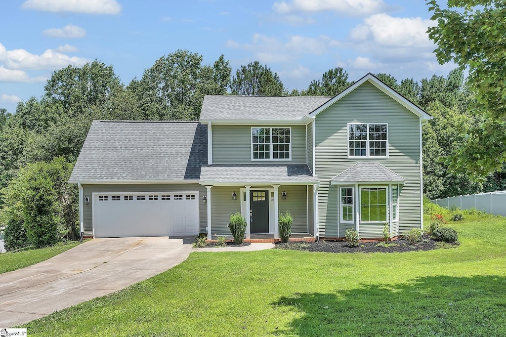 34 Perkins Ct, Greer, SC 29651 - traditional home with a garage, driveway, a shingled roof, and a porch