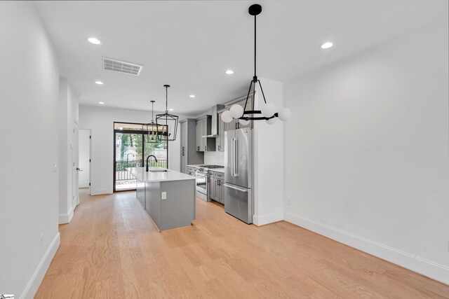 19 Conwell St, Greenville, SC 29601 - kitchen featuring stainless steel appliances, gray cabinetry, a center island with sink, light countertops, and light wood-type flooring