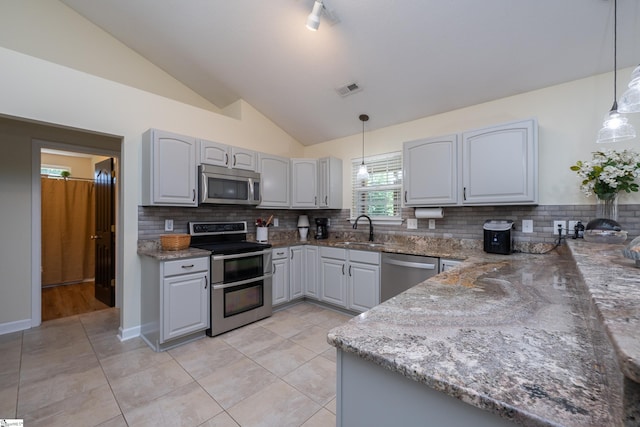 6 Gratiot Ln, Greer, SC 29651 - kitchen featuring appliances with stainless steel finishes, lofted ceiling, decorative backsplash, and stone countertops