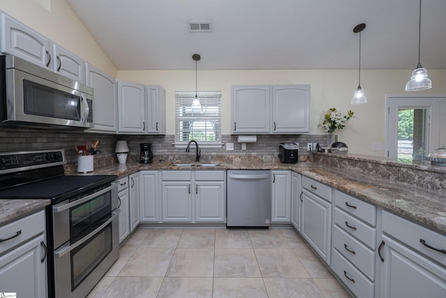 6 Gratiot Ln, Greer, SC 29651 - kitchen featuring appliances with stainless steel finishes, decorative backsplash, pendant lighting, dark stone countertops, and vaulted ceiling