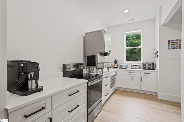 421 Lynn Rd, Taylors, SC 29687 - kitchen featuring appliances with stainless steel finishes, white cabinets, light wood-type flooring, and light countertops