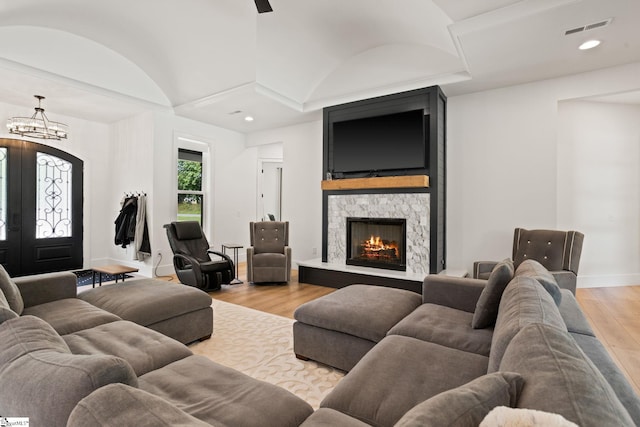 421 Lynn Rd, Taylors, SC 29687 - living room featuring light wood finished floors, a chandelier, vaulted ceiling, a stone fireplace, and recessed lighting
