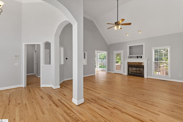10 Parkcrest Ct, Simpsonville, SC 29681 - unfurnished living room featuring a ceiling fan, high vaulted ceiling, light wood-style flooring, a fireplace, and arched walkways