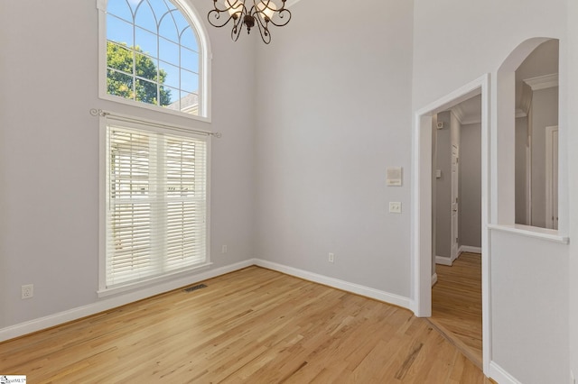 10 Parkcrest Ct, Simpsonville, SC 29681 - spare room with wood finished floors, a chandelier, a towering ceiling, and arched walkways