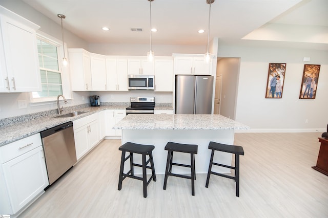111 Caylee Way, Chesnee, SC 29323 - kitchen featuring appliances with stainless steel finishes, light wood-style floors, a kitchen island, a kitchen bar, and white cabinets