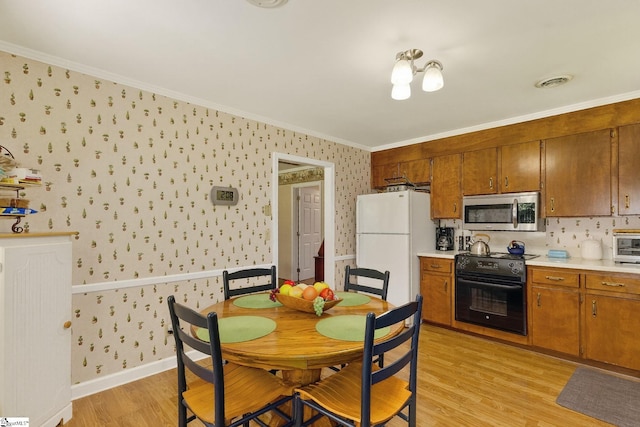 306 Verner Dr, Greenville, SC 29617 - kitchen featuring stainless steel microwave, black electric range, wallpapered walls, freestanding refrigerator, and light wood finished floors