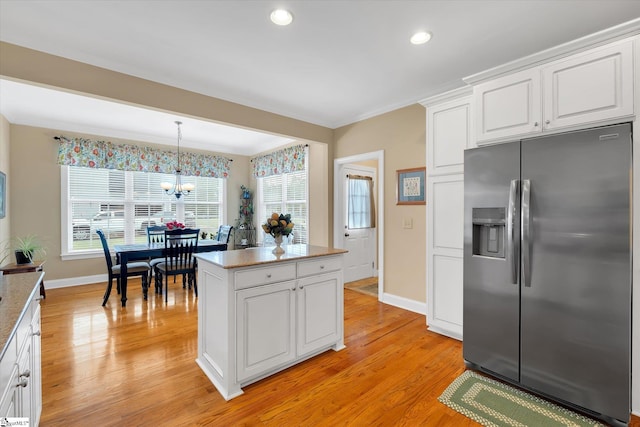 101 Edens Garden Way, Six Mile, SC 29682 - kitchen featuring stainless steel refrigerator with ice dispenser, a chandelier, light wood-type flooring, white cabinets, and decorative light fixtures