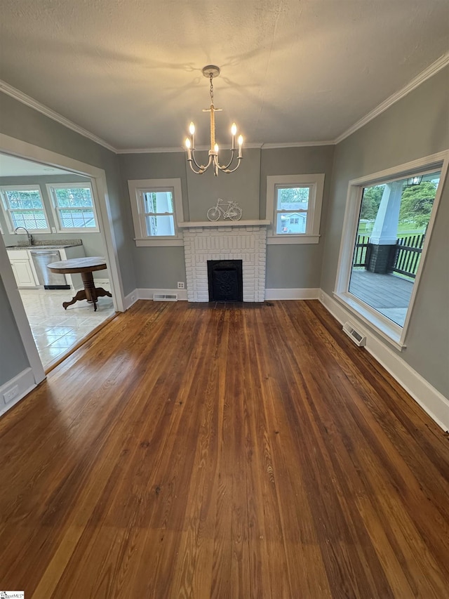 23 N Greenwood Avenue Extension, Ware Shoals, SC 29692 - unfurnished living room featuring hardwood / wood-style flooring, a chandelier, crown molding, and a fireplace