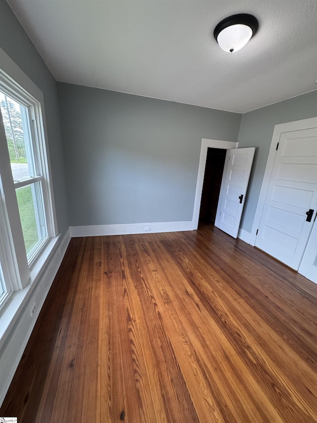 23 N Greenwood Avenue Extension, Ware Shoals, SC 29692 - unfurnished bedroom featuring baseboards and dark wood finished floors