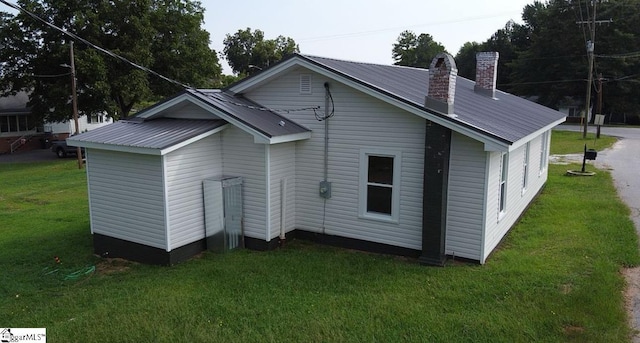 23 N Greenwood Avenue Extension, Ware Shoals, SC 29692 - view of home's exterior featuring a yard, a chimney, and a metal roof