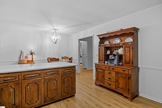 421 E Westbrooks Rd, Seneca, SC 29678 - kitchen featuring light wood-type flooring, a chandelier, light countertops, and brown cabinetry