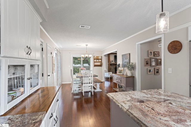 522 Reid School Rd, Taylors, SC 29687 - kitchen featuring a chandelier, ornamental molding, white cabinets, dark wood-style floors, and a textured ceiling