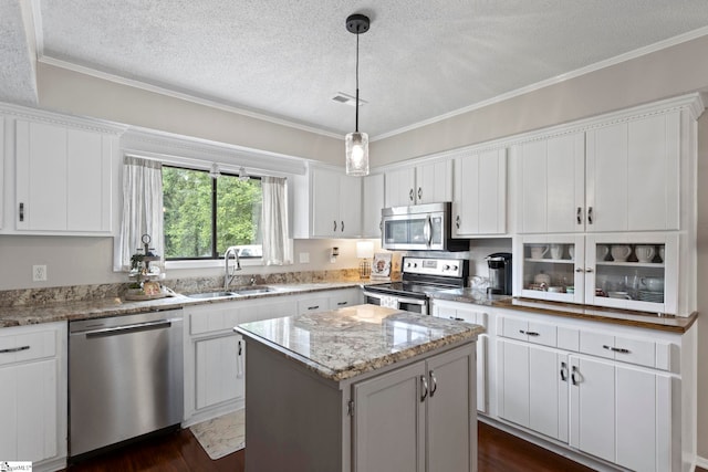 522 Reid School Rd, Taylors, SC 29687 - kitchen featuring appliances with stainless steel finishes, a textured ceiling, a kitchen island, crown molding, and white cabinets