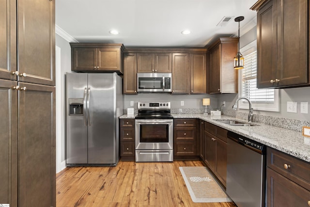 417 Addison Cir, Pelzer, SC 29669 - kitchen with stainless steel appliances, crown molding, light wood finished floors, dark brown cabinets, and light stone counters