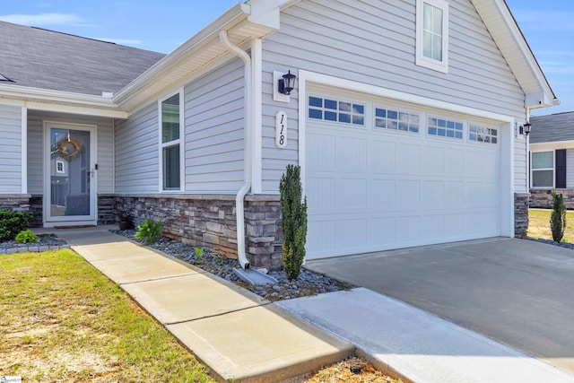 118 Sylvester St, Fountain Inn, SC 29644 - property entrance featuring a garage, stone siding, and driveway