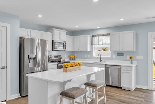 118 Sylvester St, Fountain Inn, SC 29644 - kitchen featuring appliances with stainless steel finishes, a breakfast bar area, white cabinetry, light countertops, and recessed lighting