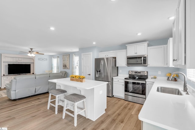 118 Sylvester St, Fountain Inn, SC 29644 - kitchen with appliances with stainless steel finishes, a breakfast bar area, open floor plan, a center island, and white cabinetry