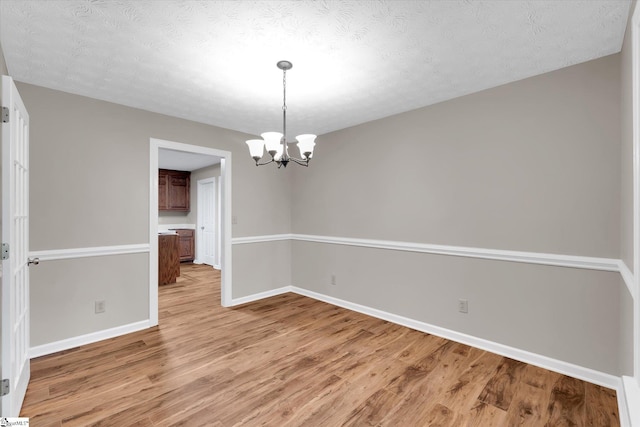 10628 Augusta Rd, Belton, SC 29627 - unfurnished room featuring light wood-style floors, a chandelier, and a textured ceiling