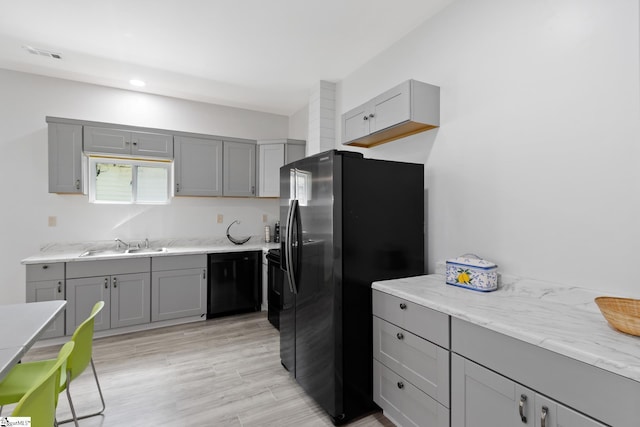 904 W Hampton St, Laurens, SC 29360 - kitchen with gray cabinetry, stainless steel fridge with ice dispenser, black dishwasher, light wood-style flooring, and recessed lighting