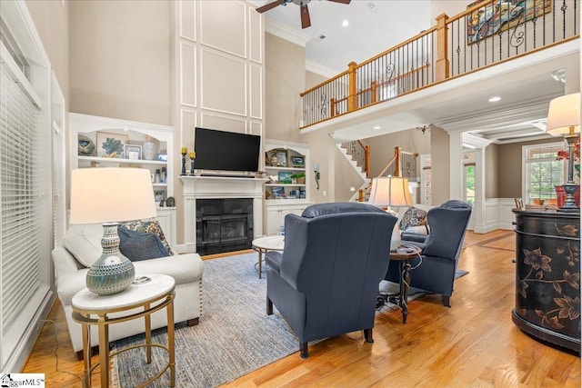 112 Griffith Hill Way, Greer, SC 29650 - living area with a towering ceiling, a ceiling fan, ornamental molding, a fireplace, and a decorative wall