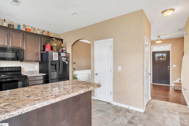8 Rivanna Dr, Anderson, SC 29625 - kitchen featuring black appliances, arched walkways, dark brown cabinetry, and light stone counters