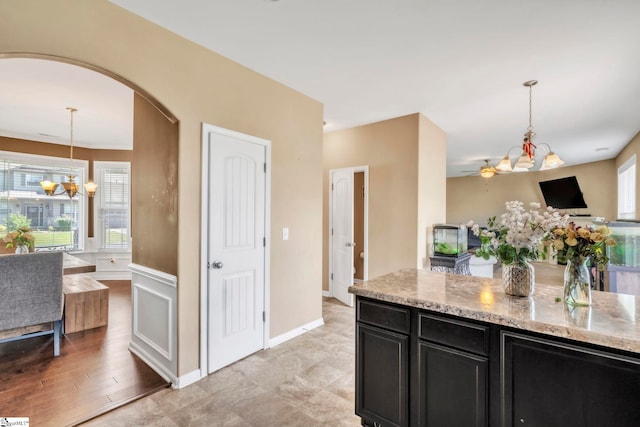 8 Rivanna Dr, Anderson, SC 29625 - kitchen with a chandelier, dark cabinetry, arched walkways, and light stone counters