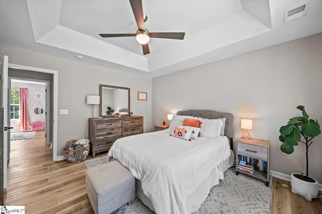 521 Omniwood Ct, Greer, SC 29651 - bedroom featuring a tray ceiling, light wood-style floors, and a ceiling fan