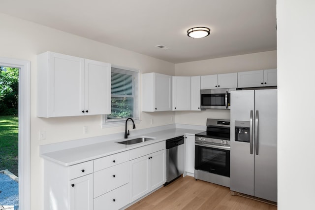 307 Echols St, Greenville, SC 29601 - kitchen with appliances with stainless steel finishes, light countertops, light wood finished floors, and white cabinets