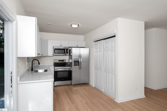307 Echols St, Greenville, SC 29601 - kitchen featuring appliances with stainless steel finishes, light countertops, light wood-style floors, and white cabinets