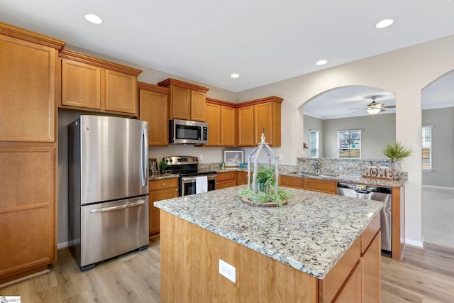 463 Lynnell Way, Moore, SC 29369 - kitchen with stainless steel appliances, arched walkways, light wood-style floors, light stone countertops, and brown cabinets
