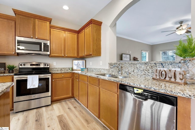 463 Lynnell Way, Moore, SC 29369 - kitchen with stainless steel appliances, light wood finished floors, arched walkways, light stone counters, and crown molding