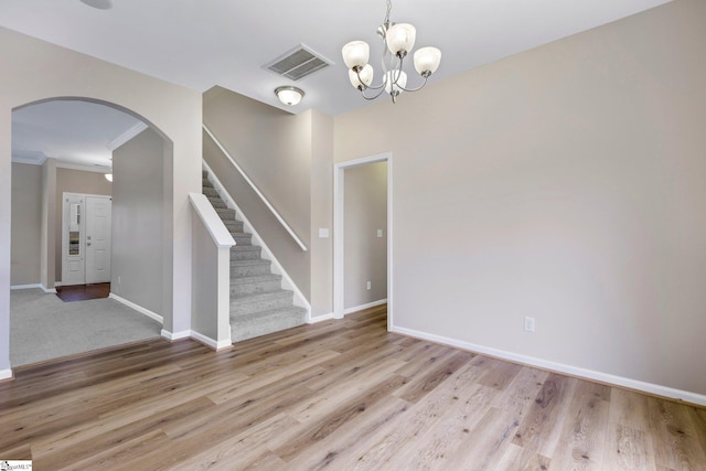 463 Lynnell Way, Moore, SC 29369 - spare room with arched walkways, light wood-type flooring, stairway, a chandelier, and crown molding