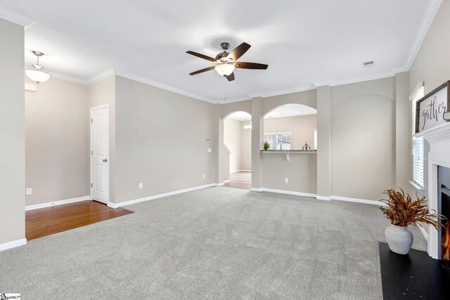 463 Lynnell Way, Moore, SC 29369 - unfurnished living room with carpet floors, a ceiling fan, arched walkways, a fireplace, and crown molding