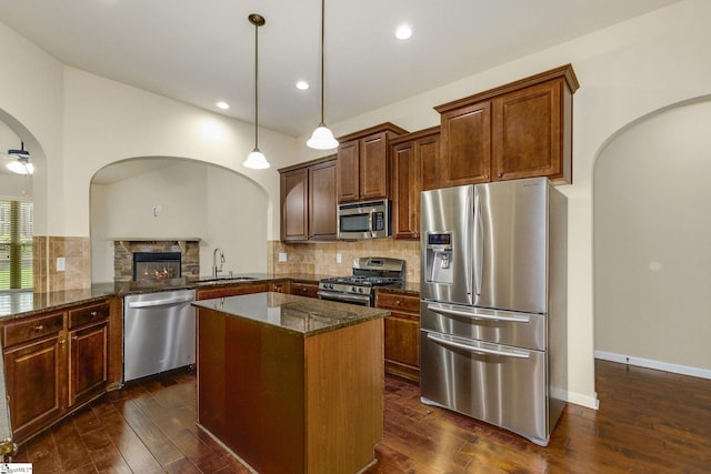 27 Dandie Dr, Simpsonville, SC 29680 - kitchen featuring stainless steel appliances, dark stone counters, dark wood-style floors, tasteful backsplash, and arched walkways