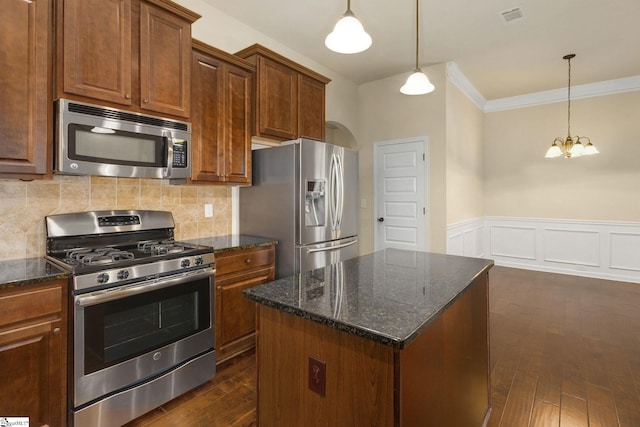 27 Dandie Dr, Simpsonville, SC 29680 - kitchen featuring appliances with stainless steel finishes, ornamental molding, dark wood-type flooring, a kitchen island, and dark stone countertops