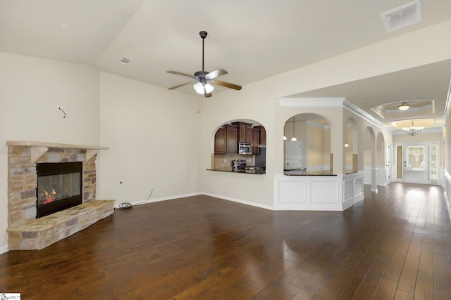 27 Dandie Dr, Simpsonville, SC 29680 - unfurnished living room with ceiling fan, a fireplace, dark wood-style flooring, and arched walkways