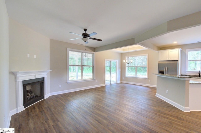 918 Belton Hwy, Williamston, SC 29691 - unfurnished living room with dark wood finished floors, ceiling fan, a fireplace, and a chandelier