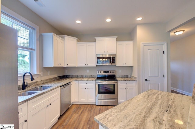 918 Belton Hwy, Williamston, SC 29691 - kitchen featuring appliances with stainless steel finishes, light wood-style floors, white cabinets, light stone countertops, and recessed lighting