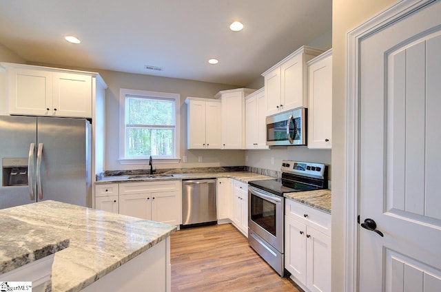 918 Belton Hwy, Williamston, SC 29691 - kitchen with stainless steel appliances, light wood-type flooring, recessed lighting, white cabinets, and light stone counters