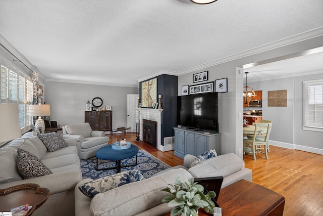 260 Riggs Dr, Clemson, SC 29631 - living area featuring ornamental molding, a chandelier, light wood finished floors, a textured ceiling, and a fireplace