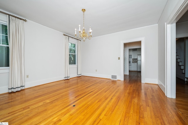 306 Mcdaniel Ave, Greenville, SC 29601 - unfurnished room featuring a chandelier, stairway, and light wood-style flooring